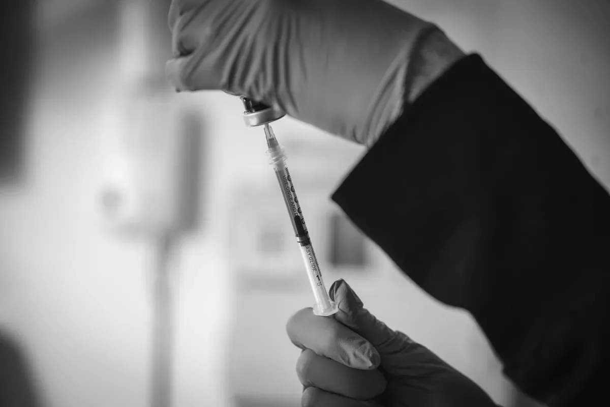 Gloved clinician hands drawing an injectable product from a vial into a syringe before a treatment. Photo: Express Med Spa (expressmedspas.com).